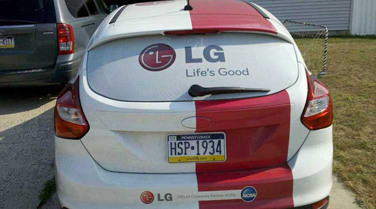 Rear view of a hatchback in a red and white color-block wrap with LG Life's Good branding across the back glass.